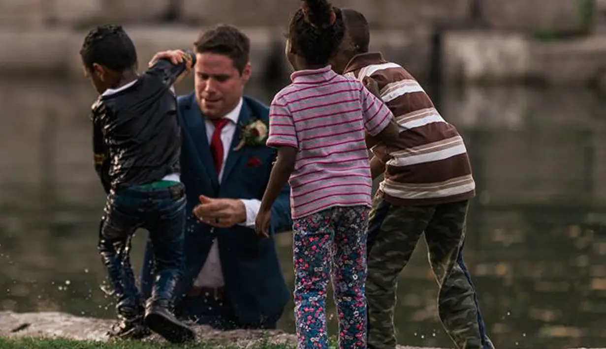 Calon pengantin pria, Clayton Cook tanpa mempedulikan setelan jasnya langsung terjun ke sungai dan menarik seorang bocah yang nyaris tenggelam ke tepian sungai. (HATT PHOTOGRAPHY / Facebook)