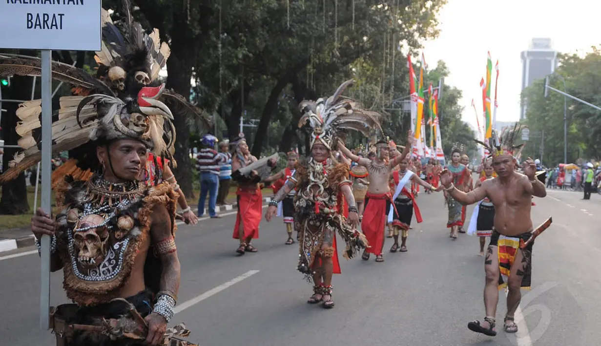 Aksi peserta dari Etnik Dayak selama kegiatan Pawai Seni & Budaya Kreatif 2014 di Jalan Medan Merdeka Barat, Jakarta, Senin (18/8/14). (Liputan6.com/Herman Zakharia)