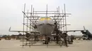 Orang-orang menyelesaikan pembuatan replika pesawat Airbus A320 skala penuh di Kaiyuan, timur laut China, 25 Oktober 2018. Secara keseluruhan, seorang petani bernama Zhu Yue telah menghabiskan 60 ton besi baja untuk membangun replika pesawat itu (STR/AFP)