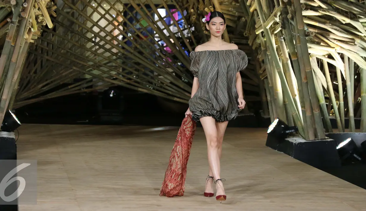 Model membawakan busana rancangan Edward Hutabarat dalam fashion show 'Kenduri' di Senayan City, Jakarta, Senin (15/8). Keunikan fashion show ini ialah ada 'rumah' yang terbuat dari 1.500 bambu. (Liputan6.com/Herman Zakharia)