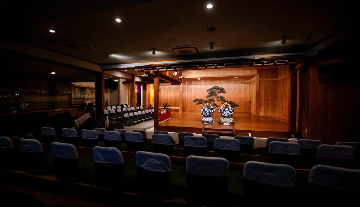 Kanta Nakamori (kiri) dan putranya Kennosuke Nakamori mengenakan topeng saat berlatih di Kamakura Noh Theatre, Kamakura, Prefektur Kanagawa, Jepang, 29 Juli 2020. Pandemi COVID-19 telah memengaruhi teater di seluruh dunia, termasuk drama sejak abad ke-14 ini. (Philip FONG/AFP)