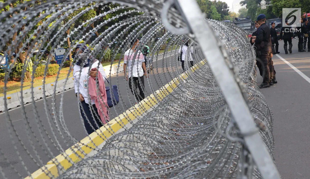 Pejalan kaki melintas di depan Gedung Mahkamah Konstitusi (MK), Jakarta, Selasa (25/6/2019). Jelang sidang pembacaan putusan akan digelar pada Kamis (27/6), sekitar 47.000 personel keamanan gabungan akan disiagakan di Ibu Kota DKI Jakarta. (Liputan6.com/Helmi Fithriansyah)