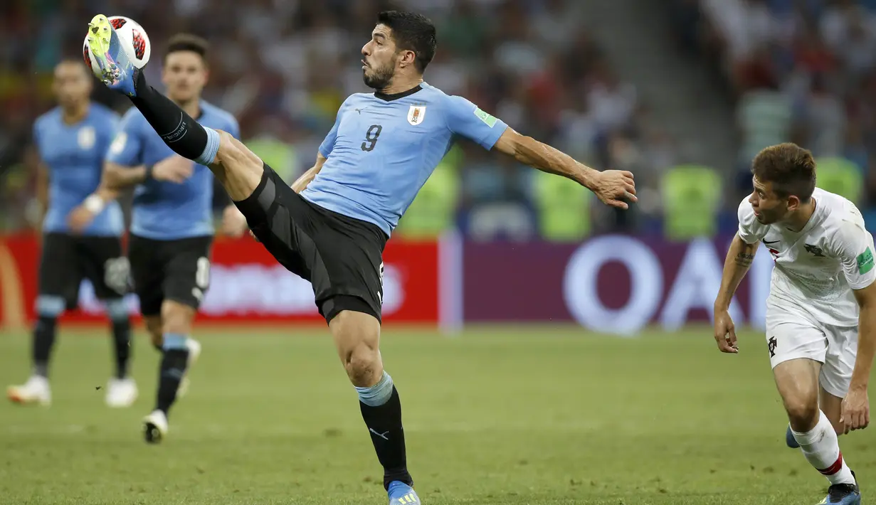 Gaya pemain Uruguay, Luis Suarez berusaha melewati adangan pemain Portugal pada laga 16 besar Piala Dunia 2018 di Fisht Stadium, Sochi, Rusia, (30/6/2018). Portugal kalah 1-2. (AP/Francisco Seco)