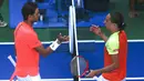 Petenis Spanyol, Rafael Nadal, bersalaman dengan petenis Ukraina, Alexandr Dolgopolov, pada turnamen AS Terbuka 2017 di New York, Senin (4/9/2017). Nadal menang 6-2, 6-4, 6-1 atas Alexandr Dolgopolov. (AP/Jason Decrow)