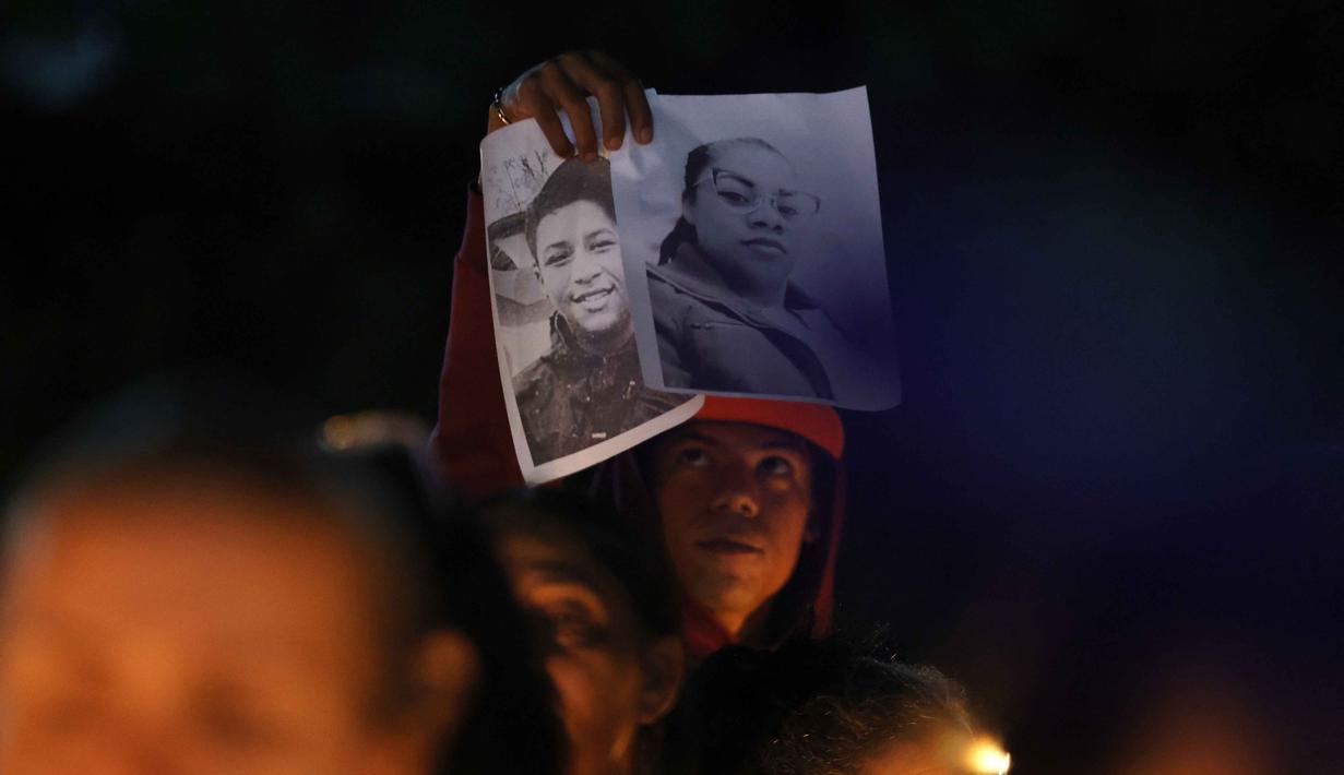 Langkah pemerintah Venezuela ini merupakan upaya untuk memenuhi tuntutan Amerika Serikat seminggu setelah penangkapan Nicolas Maduro. Tampak dalam foto, seorang pria memegang foto-foto tahanan politik selama aksi menyalakan lilin di luar penjara El Rodeo I di Guatire, Negara Bagian Miranda, sekitar 30 kilometer sebelah timur Caracas, Venezuela, pada 12 Januari 2026. (Pedro MATTEY/AFP)