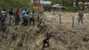 Di sisi sungai AS, para migran mengenakan pakaian kering dan melewati kawat berduri. (AP Photo/Fernando Llano)