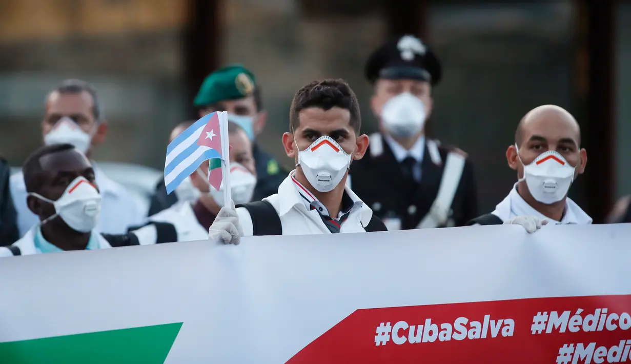 Petugas medis dan paramedis dari Kuba berpose setibanya di bandara Malpensa di Milan, Italia, Minggu (22/3/2020). Kedatangan tim medis Kuba membantu Italia mengendalikan pandemi virus Corona, salah satu negara terkaya di Eropa, merupakan yang pertama kali terjadi. (AP/Antonio Calanni)
