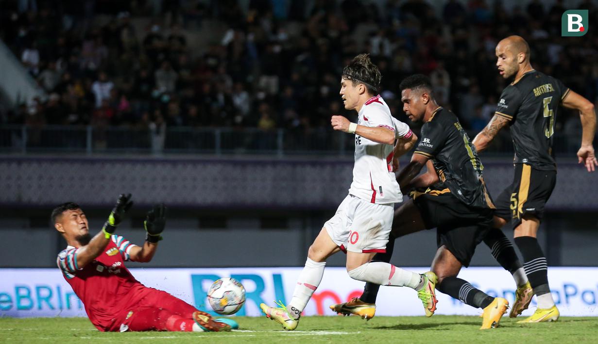 Pemain Persis Solo, Ryo Matsumura (tengah) menendang bola dihadang penjaga gawang Dewa United, M Natshir dalam pertandingan lanjutan BRI Liga 1 2022/2023 di Stadion Indomilk Arena, Tangerang, Sabtu (14/01/2023). Ryo Matsumura berhasil menjebol gawang Dewa United pada menit ke-23(Bola.com/Bagaskara Lazuardi)
