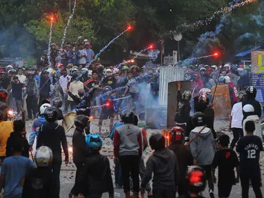 Tawuran antarwarga kembali pecah di dekat Stasiun Manggarai, Jakarta Selatan, Minggu (8/1). Puluhan orang terlihat membawa senjata tajam, bongkahan batu dan petasan. (Liputan6.com/Angga Yuniar)