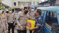 Kapolres Metro Depok memberikan paket sembako kepada pengemudi angkot di Jalan Raya Bogor, Kecamatan Sukmajaya, Kota Depok. (Liputan6.com/Dicky Agung Prihanto)