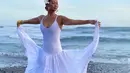 Serba putih, penampilan Indah Kalalo kali ini menggambarkan dirinya sebagai putri laut. Fitted dress dengan potongan bohemian di bagian bawah membuatnya tampil eksostis berfoto di pinggir pantai. (Instagram/indahkalalo)