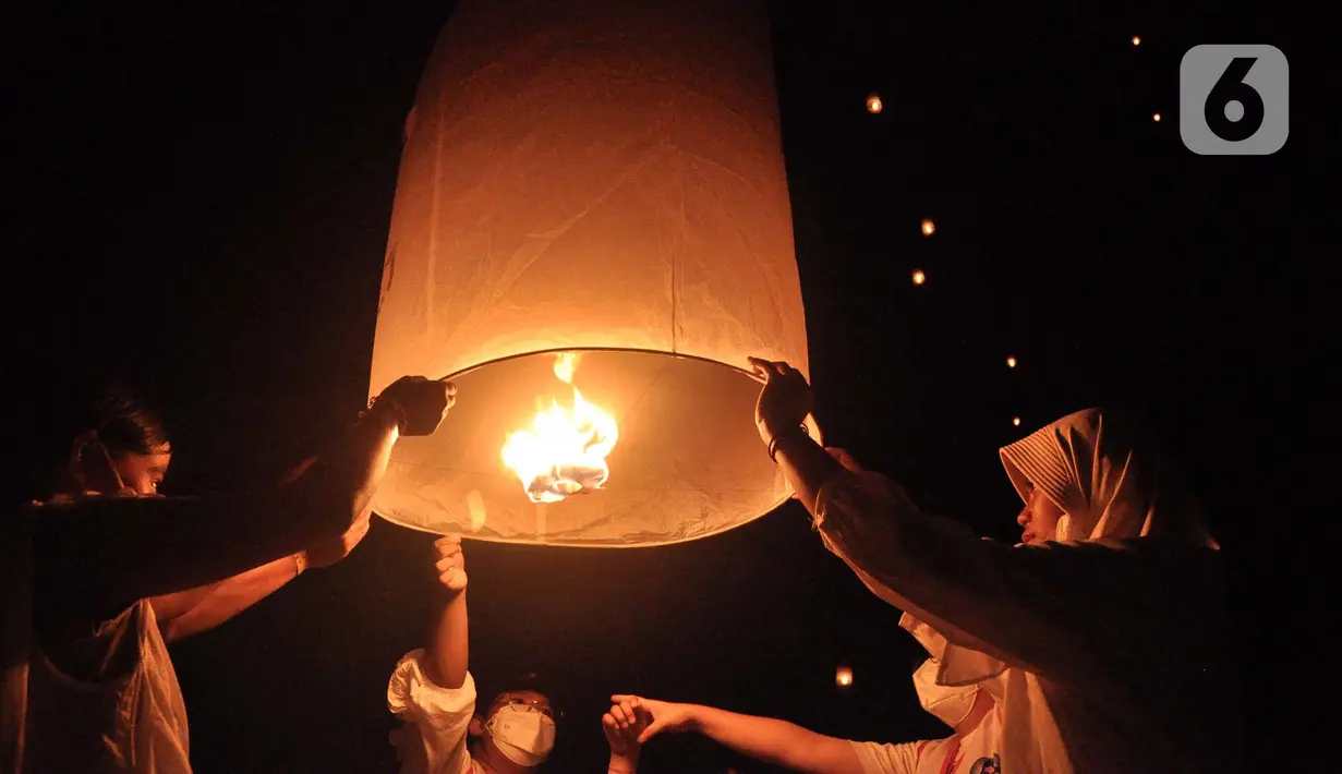 Peserta menerbangkan lampion sebagai tanda puncak perayaan Tri Suci Waisak 2566 BE/2022 di Candi Borobudur, Magelang, Jawa Tegah, Senin (16/05/2022) malam. Sebanyak 2022 lampion diterbangkan oleh biksu, umat Buddha serta wisatawan sebagai simbol harapan dan perdamaian untuk dunia. (merdeka.com/Iqbal S.Nugroho)