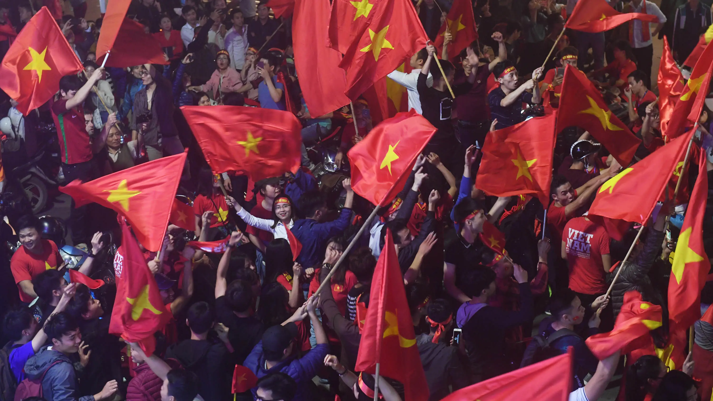 Sejumlah warga konvoi merayakan keberhasilan Vietnam mengalahkan Qatar pada semifinal Piala AFC U-23 di Hanoi, Rabu (23/1/2018). Vietnam berhasil lolos ke final untuk menantang pemenang antara Uzbekistan dan Korea Selatan. (AFP/Hoang Dinh Nam)