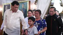 Presiden Filipina Rodrigo Duterte bersama bocah yang diculik kelompok Abu Sayyaf berada di Istana Malacanang, Manila, Filipina, Selasa (28/2). Duterte mengaku tidak ada uang tebusan untuk membebaskan bocah Filipina tersebut. (AP Photo)