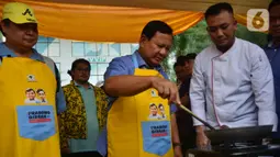 Prabowo dan Airlangga yang sudah memakai celemek pun mendatangi booth untuk memasak nasi goreng. Prabowo terlihat mengaduk-aduk wajan untuk membuat nasi goreng. (merdeka.com/Arie Basuki)