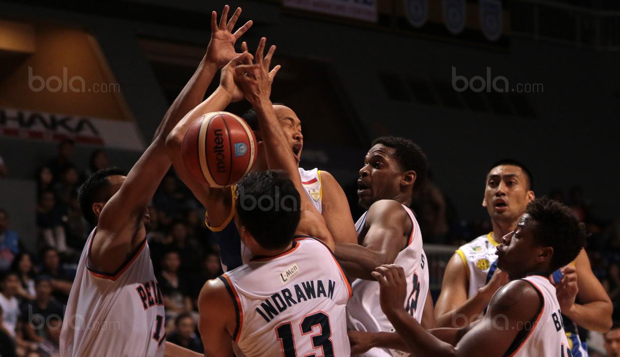 Pemain Satria Muda, Arki Wisnu (2kiri) gagal melewati adangan para pemain Pelita Jaya pada laga Perbasi Cup 2017 di Sports Mall, Kelapa Gading, Jakarta, (10/11/2017). Pelita Jaya menang 82-77.  (Bola.com/Nick Hanoatubun)