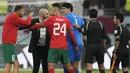Pelatih Maroko, Walid Regragui (dua kiri) dan kapten tim, Roman Saiss (kiri) juga berkonfrontasi dengan Abdulrahman Al Jassim (dua kanan). Mereka menunjukkan kegeraman terhadap sang pengadil laga. (AP Photo/Thanassis Stavrakis)