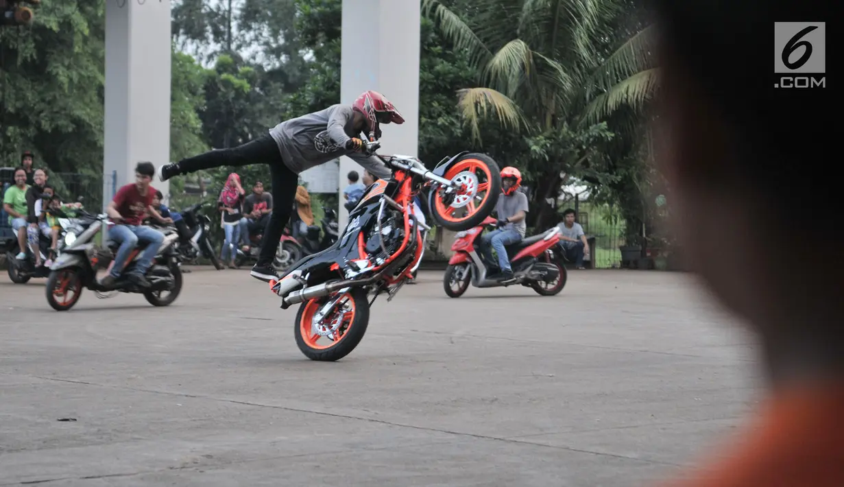 Para freestyler motor menunjukkan keahliannya saat meramaikan waktu menjelang berbuka puasa atau ngabuburit di Banjir Kanal Timur (BKT), Jakarta, Minggu (12/5/2019). Acara ini digelar oleh komunitas freestyle motor gabungan Jakarta-Bekasi. (merdeka.com/Iqbal Nugroho)
