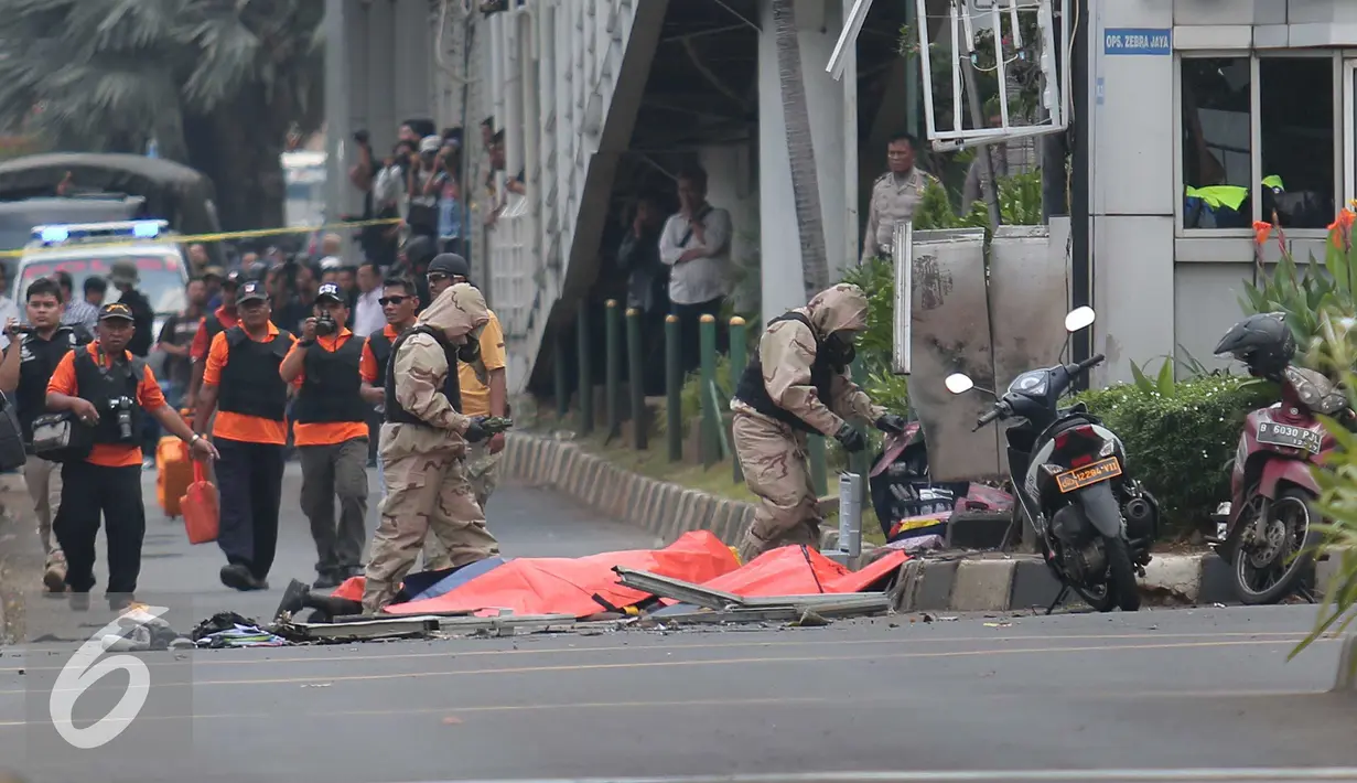 Petugas menutup mayat korban ledakan bom di pos pol sarinah, Jakarta, Kamis, (14/1/2016). Beberapa ledakan dan suara senjata api terjadi di pusat ibukota Indonesia, Polisi mencurigai seorang melakukan aksi bom bunuh diri. (Liputan6.com/Angga Yuniar)