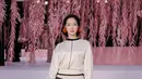 Kim Go Eun tampil feminin setelan long sleeve satin dan rok midi A-line dengan detail garis. Anting merah dengan aksen spike jadi aksesori yang statement [Chanel]