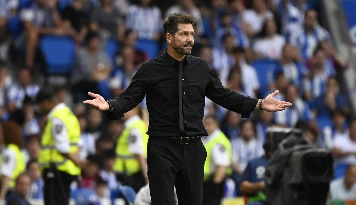 Pelatih Atletico Madrid, Diego Simeone melakukan protes kepada wasit saat timnya bertamu ke kandang Real Sociedad. Ia pun harus diganjar kartu kuning atas perbuatannya pada injury time babak pertama. (AFP/Pierre-Philippe Marcou)