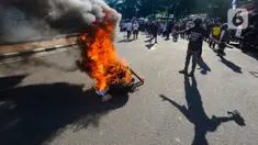Massa membakar poster dan ban bekas saat aksi terkait putusan sengketa Pilpres di MK, di kawasan bundaran Patung Kuda, Jakarta, Senin (22/4/2024). (merdeka.com/Arie Basuki)