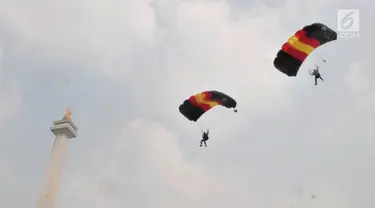 Aksi penerjun payung saat Festival Damai Millenial Road Safety di Monas, Jakarta, Minggu (23/6/2019). Aksi ini diikuti puluhan penerjun payung dari personel gabungan TNI-Polri. (merdeka.com/Iqbal Nugroho)