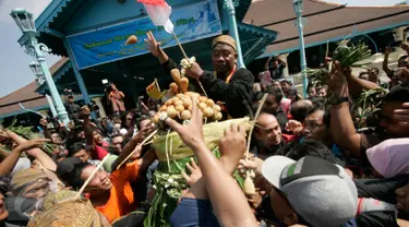 Warga memperebutkan sesaji gunungan pada acara Grebeg Syawal di halaman Masjid Agung Solo, Jawa Tengah, Jumat (8/7). Grebeg Syawal merupakan tradisi Keraton Kasunanan Surakarta untuk merayakan Idul Fitri. (Liputan6.com/Boy Harjanto)