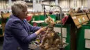 Seorang wanita merapihkan bulu anjing Bedlington Terrier-nya sebelum tampi pada hari kedua pertunjukan anjing Crufts di National Exhibition Centre di Birmingham, Inggris tengah, (9/3). (AFP Photo/Oli Scarff)