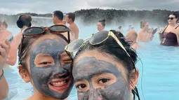 Tak hanya berendam, Febby juga turut mencoba masker lumpur yang terkenal dari Blue Lagoon. Dalam foto lainnya, ia terlihat bersama rekannya, wajah mereka penuh masker lumpur abu-abu, yang dipercaya baik untuk kesehatan kulit. Suasana relaksasi bercampur keceriaan terlihat dari pose mereka yang bersahabat dan penuh tawa.  (Liputan6.com/IG/@febbyrastanty)