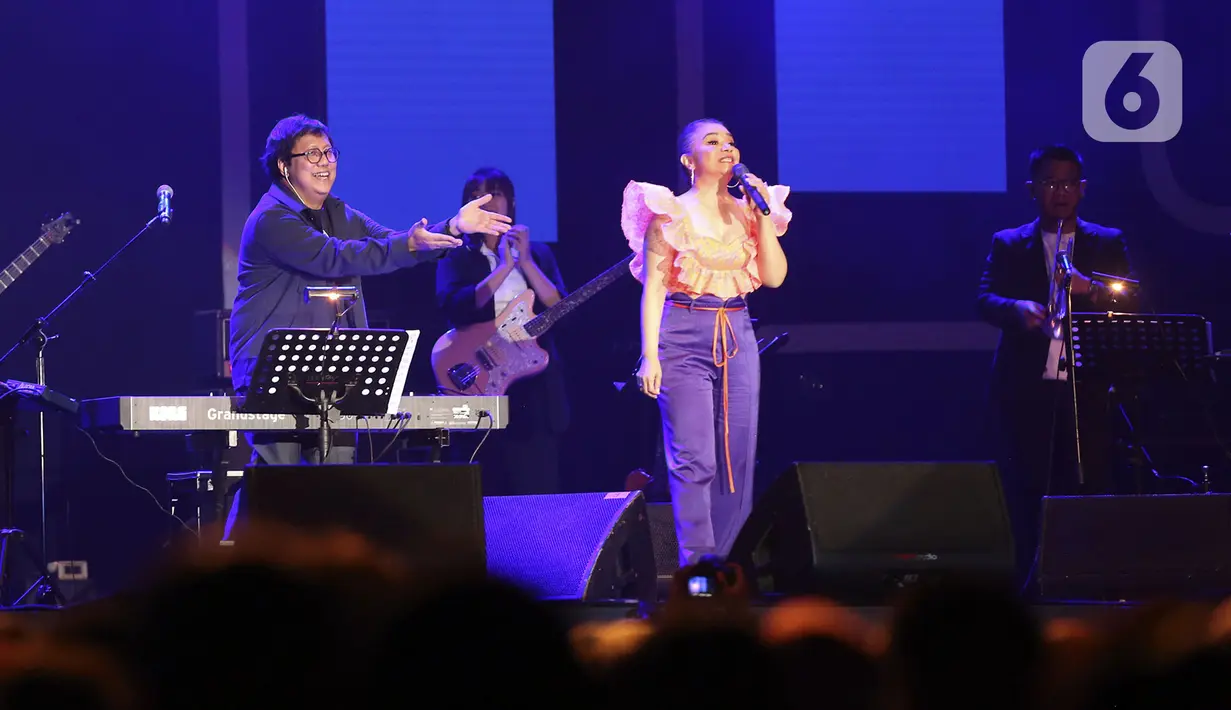 Komposer Erwin Gutawa (kiri) memberi isyarat terhadap penyanyi Ruth Sahanaya (kedua kanan) saat berkolaborasi pada hari pertama BNI Java Jazz Festival 2022 di JIExpo Kemayoran, Jakarta, Jumat (27/5/2022). Java Jazz Festival 2022 digelar pada 27-29 Mei setelah vakum selama dua tahun akibat pandemi COVID-19. (Liputan6.com/Johan Tallo)