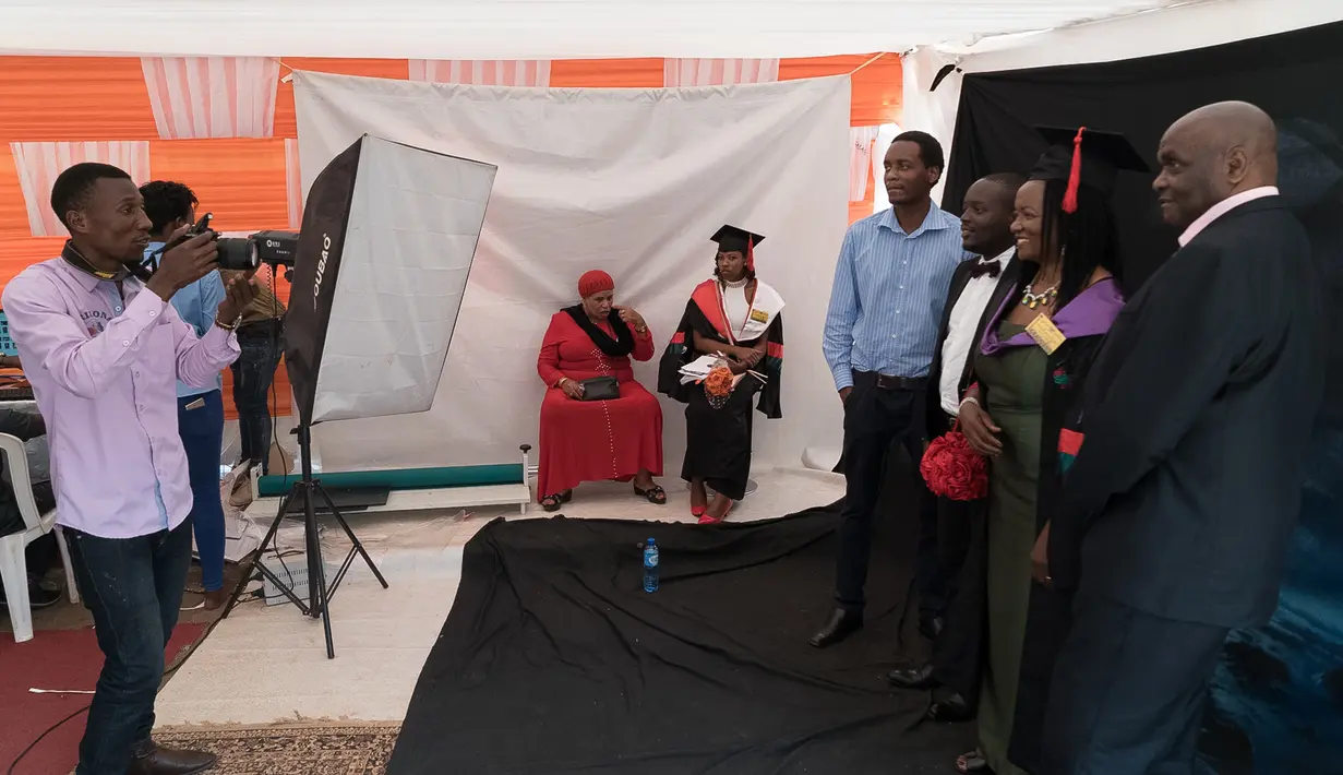 Wisudawan berfoto bersama keluarga mereka usai mengikuti upacara wisuda ke-68 di Universitas Makerere di Kampala, Uganda (19/1). (AFP Photo/Michele Sibiloni)