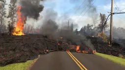 Pemandangan lava pijar erupsi Gunung Kilauea yang menutupi jalan di Pahoa, Hawaii, Amerika Serikat, Sabtu (5/5). Warga menuturkan, suara aliran lava terdengar seperti deru mesin jet. (U.S. Geological Survey via AP)