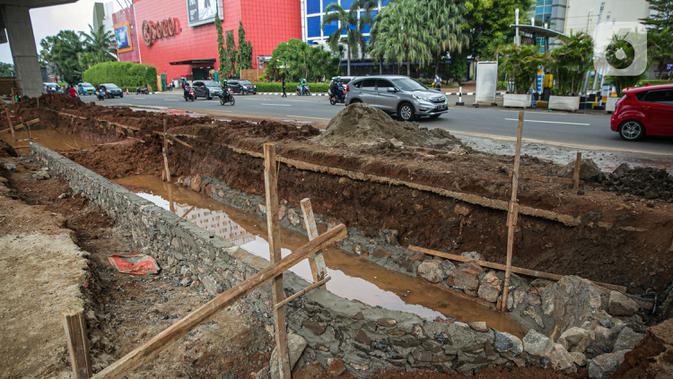 Suasana proyek pembangunan kolam olakan air di Kelapa Gading, Jakarta, Minggu (31/1/2021). Pembuatan kolam olakan air ini dilakukan untuk mengantisipasi dan menampung genangan air sementara di jalan raya saat hujan, yang kemudian akan dialirkan ke sungai atau laut. (Liputan6.com/Faizal Fanani)