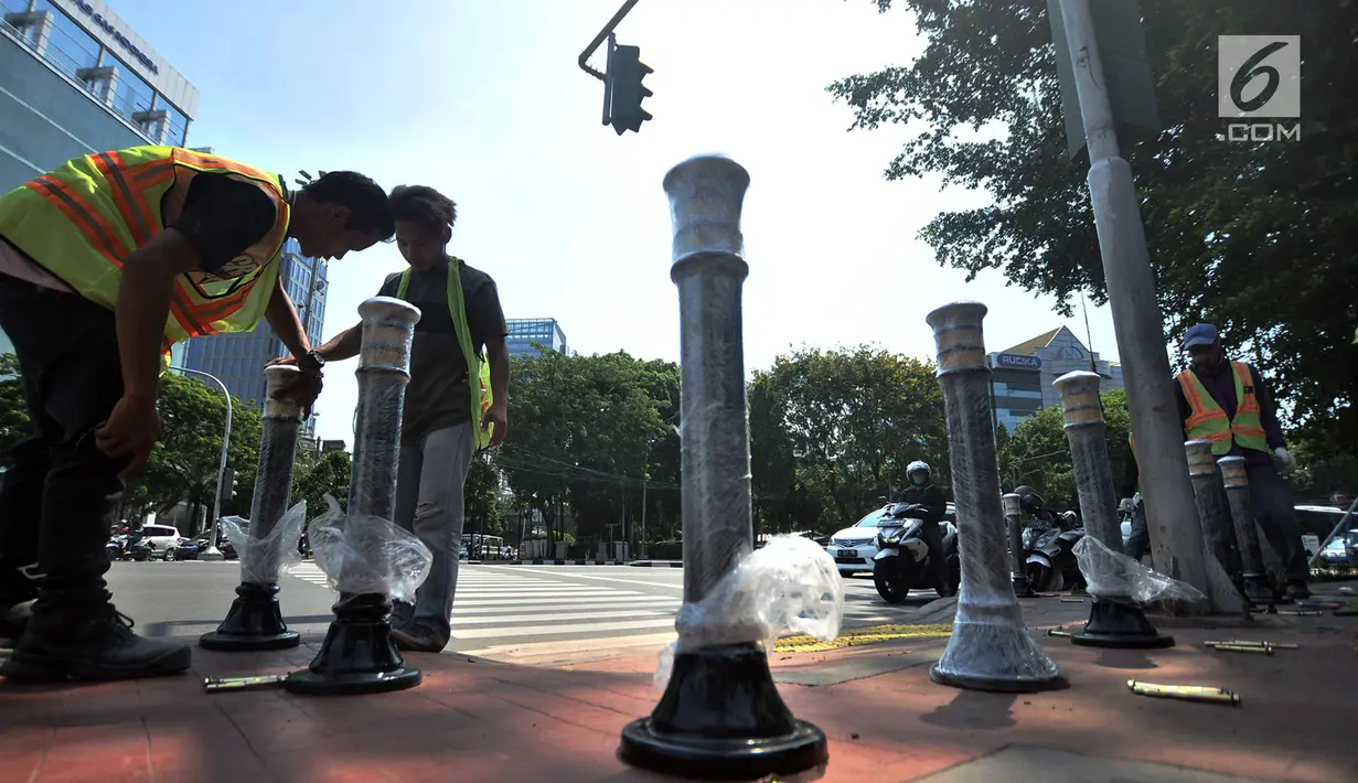 Pekerja memasang Bolar atau tiang pembatas pedestrian di kawasan Tugu Tani, Jakarta, Minggu (9/9). Pemasangan Bolar bertujuan menjaga keindahan jalur pedestrian dan mencegah penyalahgunaan fungsi.(merdeka.com/ Iqbal S. Nugroho)