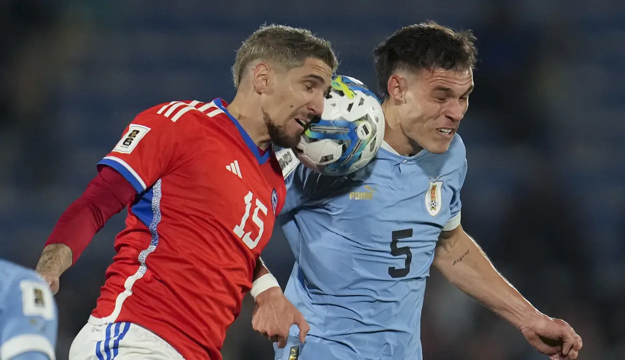 Gelandang Uruguay Nahitan Nandez (kanan) berebut bola  bek Chile Gabriel Suazo dalam Kualifikasi Piala Dunia 2026 zona CONMEBOL di Estadio Centenario, Sabtu (9/9/2023) pagi WIB. (Pablo PORCIUNCULA / AFP)