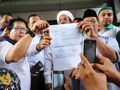 Perwakilan organisasi massa menunjukkan berkas laporan usai melaporkan Gubernur DKI Jakarta, Basuki Tjahaja Purnama ke Bareskrim Mabes Polri di KKP, Jakarta, Jumat (7/10). Ahok dilaporkan atas dugaan penodaan agama. (Liputan6.com/Helmi Fithriansyah)