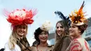 Wanita-wanita cantik mengunakan topi unik foto bersama sambut pembukaan ajang Pacuan Kuda dalam Festival Cheltenham di Inggris, (16/3). Pacuan kuda merupakan olahraga yang disukai oleh kerajaan Inggris. (REUTERS/Paul Childs)