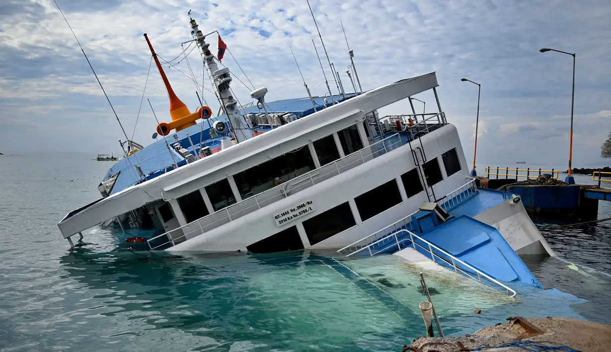 KMP Dharma Rucitra III kandas di Pelabuhan Padang Bai, Karangasem, Bali, Sabtu (13/6/2020). Beberapa kendaraan termasuk truk dan sepeda motor masih terjebak di dalamnya. (SONNY TUMBELAKA/AFP)