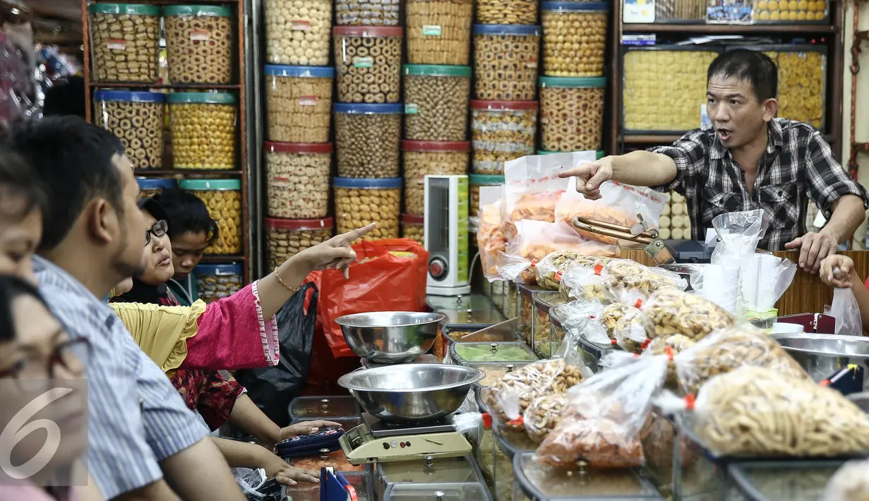 Suasana pembelian kue di salah satu toko di di Pasar Jatinegara, Jakarta, Senin (27/6). Alasan warga membeli panganan khas lebaran di toko kue karena lebih praktis dan terjangkau harganya. (Liputan6.com/Faizal Fanani)