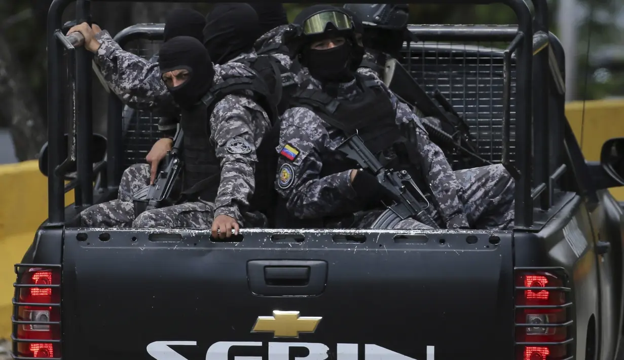 Pasukan khusus venezuela berpatroli di jalan raya Junquito dalam operasi penangkapan Oscar Perez di Caracas, Venezuela, Senin (15/1). Pasukan khusus Venezuela saling tembak dengan pemberontak yang melarikan diri sejak tahun lalu. (AP Photo/Fernando Llano)