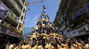 Ribuan umat Hindu membentuk piramida manusia untuk mencapai dan memecahkan dahi-handi (pot yang terbuat dari tanah liat) pada Festival Janmashtami di Mumbai, India, 6 September 2015. Festival ini menandai kelahiran dewa Krishna (REUTERS/Danish Siddiqui)