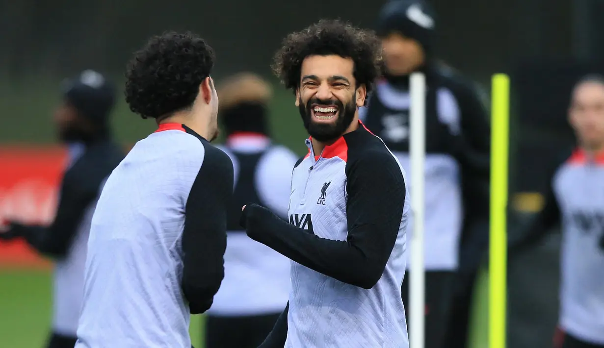Pemain Liverpool Mohamed Salah (kanan) bercanda dengan Curtis Jones (kiri) saat sesi latihan tim di Pusat Pelatihan AXA, Liverpool, Inggris, 20 Februari 2023. Liverpool akan menghadapi pertandingan sepak bola leg pertama babak 16 besar Liga Champions UEFA melawan Real Madrid. (Lindsey Parnaby/AFP)