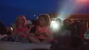 Orang-orang menonton film di luar ruangan saat pemutaran film drive-in di Family Drive-in, Virginia, 10 Agustus 2018. Drive-in merupakan bagian penting dalam industri hiburan di Amerika. (AFP PHOTO/Nicholas Kamm)