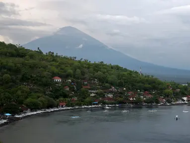 Lanskap Gunung Agung terlihat dari kawasan Pantai Amed, Karangasem, Bali, Rabu (6/12). Kawasan Amed menjadi salah satu lokasi favorit bagi wisatawan untuk menikmati matahari terbenam serta lansekap Gunung Agung. (Liputan6.com/Immanuel Antonius)