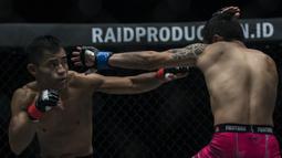 Atlet MMA Indonesia, Stefer Rahardian, tukar pukulan dengan atlet MMA China, Peng Xue Wen, pada kelas strawweight di JCC Senayan, Jakarta, Sabtu (22/9/2018). Stefer Rahardian kalah dari Peng Xue Wen. (Bola.com/Vitalis Yogi Trisna)