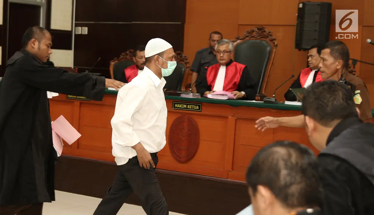 Terdakwa kasus penembakan dr Letty Sultri, dr Helmi menghampiri kuasa hukumnya saat sidang mendengarkan dakwaan di PN Jakarta Timur, Kamis (29/3). Helmi didakwa telah menembak istrinya hingga tewas pada 9 November 2017. (Liputan6.com/Herman Zakharia)