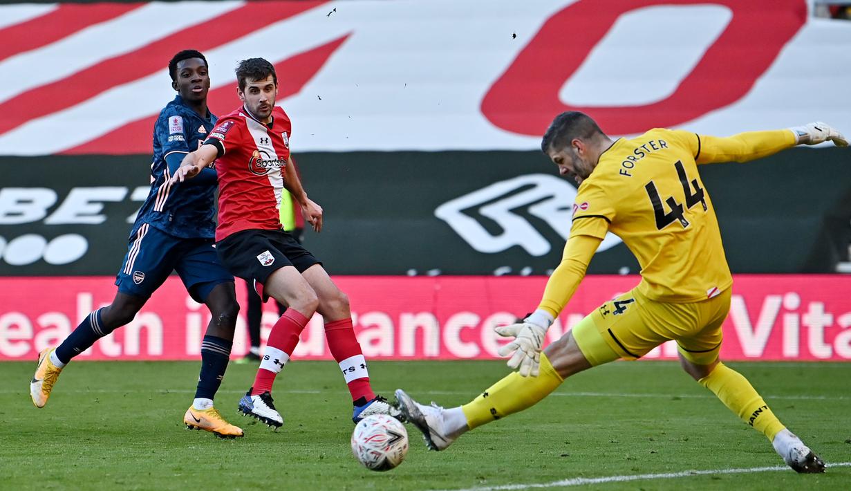 Kiper Southampton, Fraser Forster, menghalau bola tendangan pemain Arsenal, Eddie Nketiah, pada laga Piala FA di Stadion St Mary, Sabtu (23/1/2021). Arsenal tumbang dengan skor 1-0. (AFP/Ben Stansall)