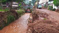 Tumpukan sisa material lumpur dan kayu di dekat Jembatan Srigading, Lawang, Malang pasca bencana banjir bandang yang terjadi di wilayah itu pada Selasa, 8 Maret 2022 (Zainul Arifin/Liputan6.com)