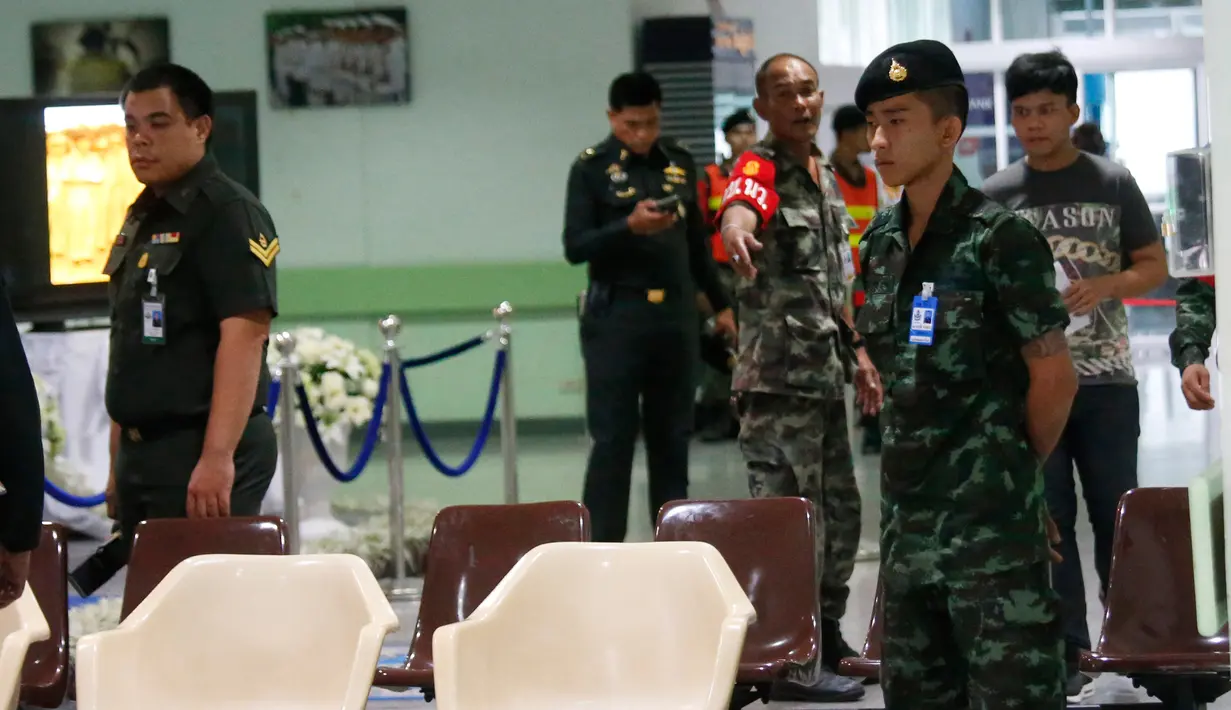 Seorang tentara Thailand berjaga-jaga saat petugas polisi menyelidiki lobi Rumah Sakit Phramongkutklao, Bangkok, (22/5). Wakil kepala polisi Thailand mengatakan, penyidik menemukan jejak baterai dan kabel di lokasi ledakan. (AP Photo/Sakchai Lalit)